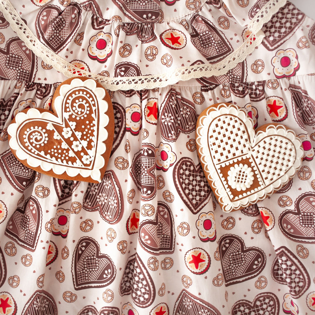 Girls' cotton dress Ginger, inspired by Czech gingerbread patterns, perfect for Christmas. Dívčí bavlněné šaty Perníček, inspirované vzory českého perníku, ideální na Vánoce, vyrobené z vysoce kvalitních švýcarských látek.