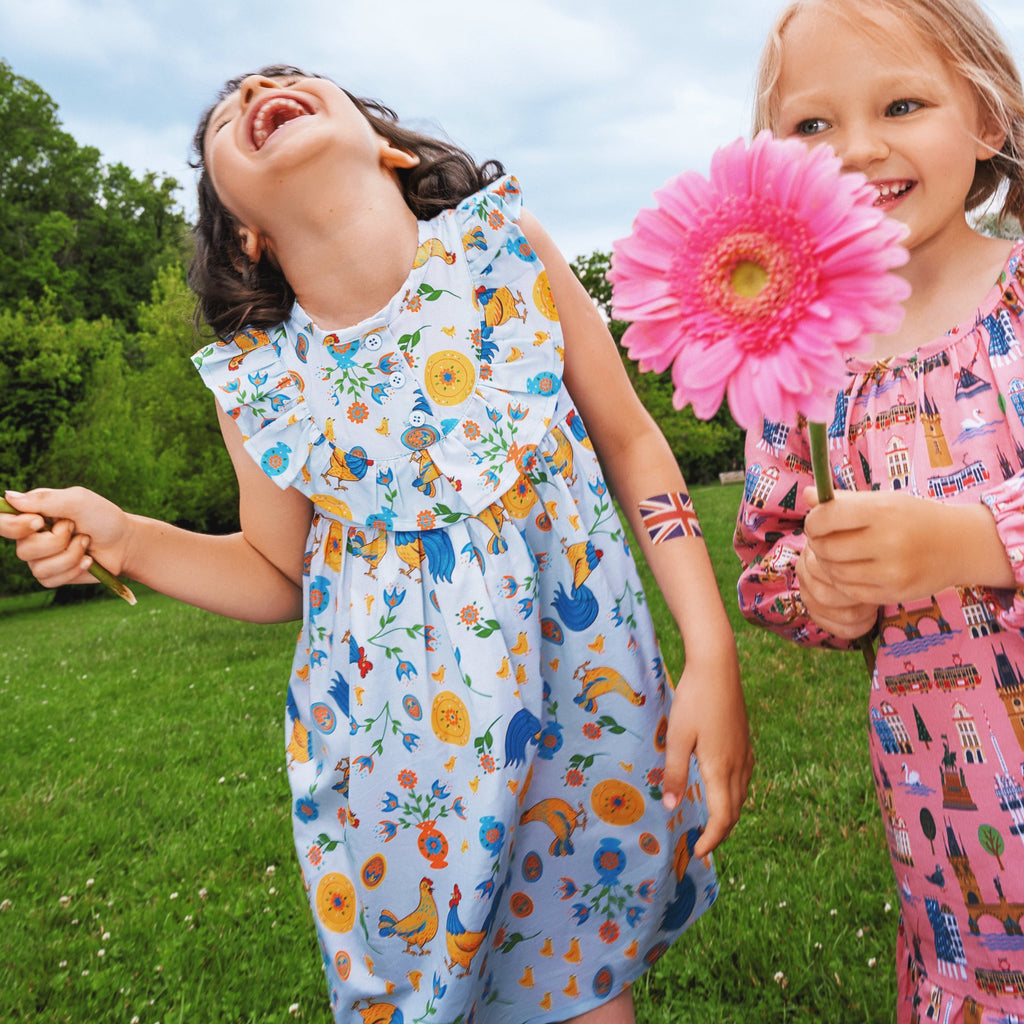Girls' cotton dress Xenia with traditional Eastern European rooster and chick design, symbolizing prosperity and cultural heritage.
Dívčí bavlněné šaty Ksenia s tradičními východoevropskými motivy kohouta a kuřátek, symbolizujícími prosperitu a kulturní dědictví.