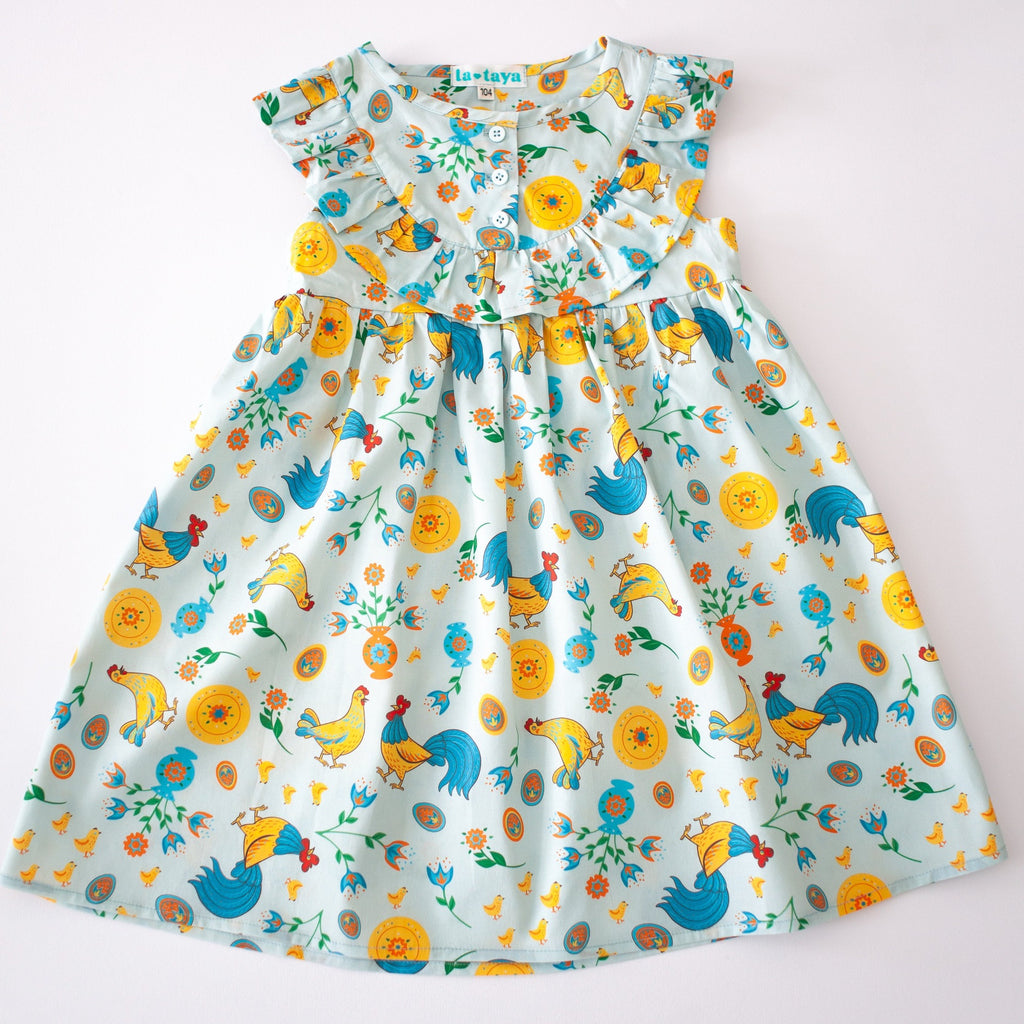 Girls' cotton dress Xenia with traditional Eastern European rooster and chick design, symbolizing prosperity and cultural heritage.
Dívčí bavlněné šaty Ksenia s tradičními východoevropskými motivy kohouta a kuřátek, symbolizujícími prosperitu a kulturní dědictví.