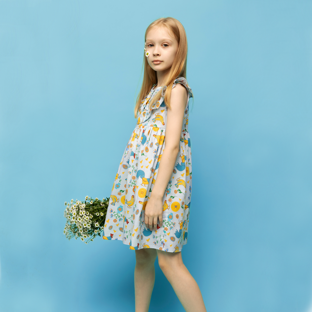 Girls' cotton dress Xenia with traditional Eastern European rooster and chick design, symbolizing prosperity and cultural heritage.
Dívčí bavlněné šaty Ksenia s tradičními východoevropskými motivy kohouta a kuřátek, symbolizujícími prosperitu a kulturní dědictví.