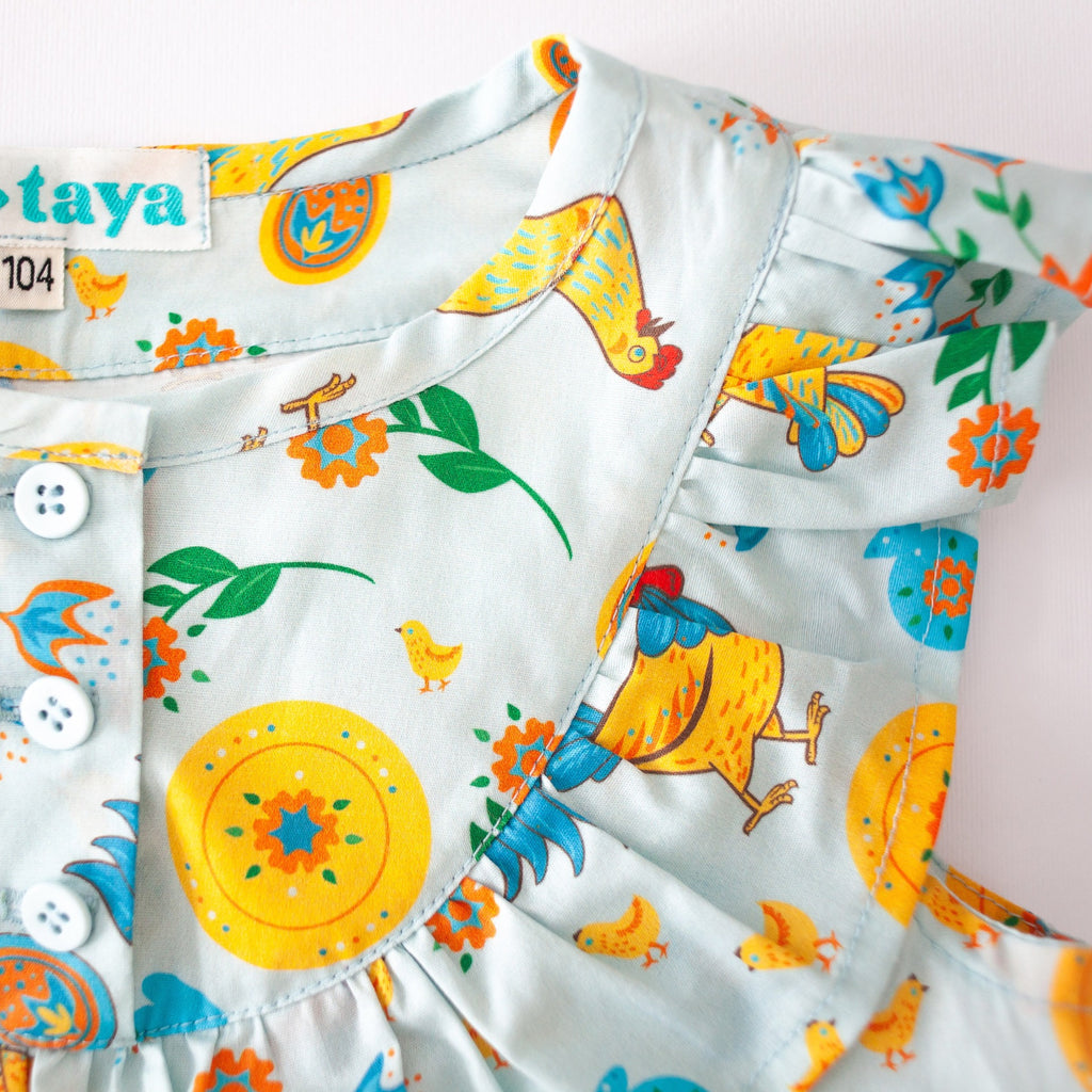 Girls' cotton dress Xenia with traditional Eastern European rooster and chick design, symbolizing prosperity and cultural heritage.
Dívčí bavlněné šaty Ksenia s tradičními východoevropskými motivy kohouta a kuřátek, symbolizujícími prosperitu a kulturní dědictví.