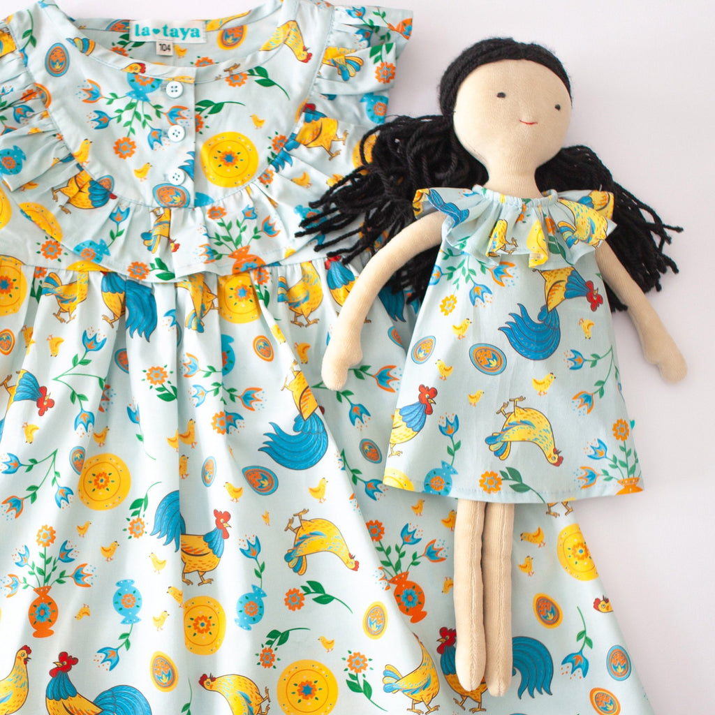 Girls' cotton dress Xenia with traditional Eastern European rooster and chick design, symbolizing prosperity and cultural heritage.
Dívčí bavlněné šaty Ksenia s tradičními východoevropskými motivy kohouta a kuřátek, symbolizujícími prosperitu a kulturní dědictví.